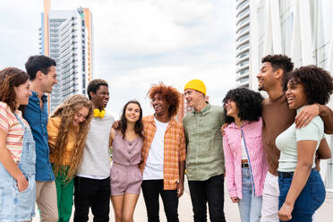 Happy playful multiethnic group of young friends bonding outdoors - Multiracial millennials students meeting in the city, concepts of youth, people lifestyle, diversity, teenage and urban life - DMDF09010