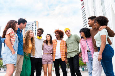 Happy playful multiethnic group of young friends bonding outdoors - Multiracial millennials students meeting in the city, concepts of youth, people lifestyle, diversity, teenage and urban life - DMDF09017