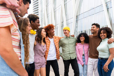 Happy playful multiethnic group of young friends bonding outdoors - Multiracial millennials students meeting in the city, concepts of youth, people lifestyle, diversity, teenage and urban life - DMDF09018