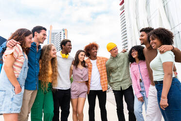 Happy playful multiethnic group of young friends bonding outdoors - Multiracial millennials students meeting in the city, concepts of youth, people lifestyle, diversity, teenage and urban life - DMDF09020