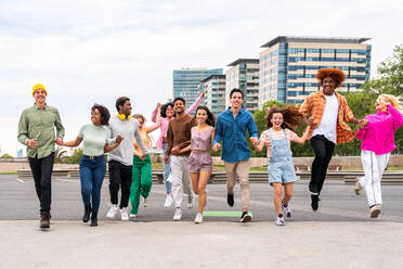 Happy playful multiethnic group of young friends bonding outdoors - Multiracial millennials students meeting in the city, concepts of youth, people lifestyle, diversity, teenage and urban life - DMDF09088