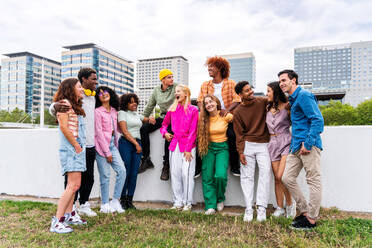 Happy playful multiethnic group of young friends bonding outdoors - Multiracial millennials students meeting in the city, concepts of youth, people lifestyle, diversity, teenage and urban life - DMDF09125