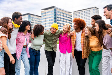 Happy playful multiethnic group of young friends bonding outdoors - Multiracial millennials students meeting in the city, concepts of youth, people lifestyle, diversity, teenage and urban life - DMDF09127