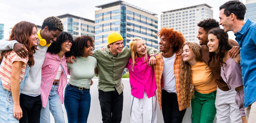 Happy playful multiethnic group of young friends bonding outdoors - Multiracial millennials students meeting in the city, concepts of youth, people lifestyle, diversity, teenage and urban life - DMDF09128