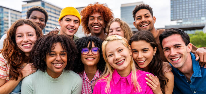 Happy playful multiethnic group of young friends bonding outdoors - Multiracial millennials students meeting in the city, concepts of youth, people lifestyle, diversity, teenage and urban life - DMDF09142