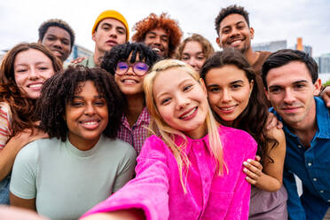 Happy playful multiethnic group of young friends bonding outdoors - Multiracial millennials students meeting in the city, concepts of youth, people lifestyle, diversity, teenage and urban life - DMDF09145