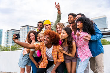 Happy playful multiethnic group of young friends bonding outdoors - Multiracial millennials students meeting in the city, concepts of youth, people lifestyle, diversity, teenage and urban life - DMDF09150