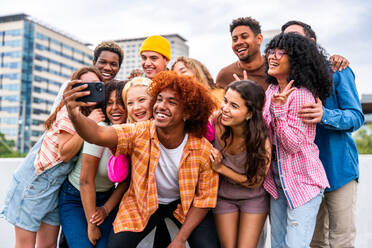 Happy playful multiethnic group of young friends bonding outdoors - Multiracial millennials students meeting in the city, concepts of youth, people lifestyle, diversity, teenage and urban life - DMDF09152