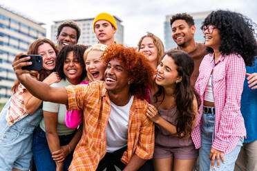 Happy playful multiethnic group of young friends bonding outdoors - Multiracial millennials students meeting in the city, concepts of youth, people lifestyle, diversity, teenage and urban life - DMDF09153