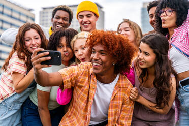 Happy playful multiethnic group of young friends bonding outdoors - Multiracial millennials students meeting in the city, concepts of youth, people lifestyle, diversity, teenage and urban life - DMDF09154