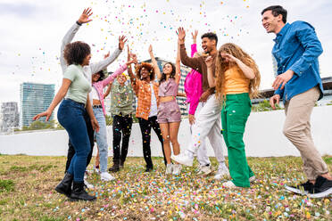 Happy playful multiethnic group of young friends bonding outdoors - Multiracial millennials students meeting in the city, concepts of youth, people lifestyle, diversity, teenage and urban life - DMDF09161