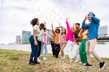 Happy playful multiethnic group of young friends bonding outdoors - Multiracial millennials students meeting in the city, concepts of youth, people lifestyle, diversity, teenage and urban life - DMDF09162