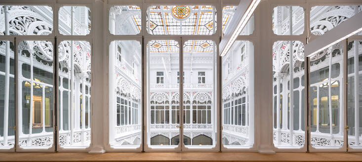 Interior of modern hallway with hanging light with large glass door and windows in library - ADSF51207