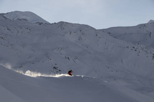 Side view of Unrecognizable male backpacker in warm clothes skiing on snowy mountains in Zermatt, Switzerland under blue sky - ADSF51439