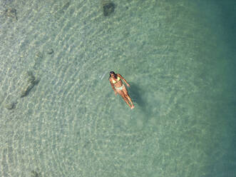 An aerial image showcasing a single individual blissfully floating in the crystal-clear turquoise waters of the Côte D’Azur in Nice, France. - ADSF51520