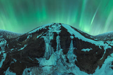 Captivating aurora borealis illuminating the night sky above Iceland's snow-covered mountains, highlighting the natural beauty of this Arctic landscape. - ADSF51552