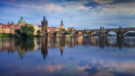 Panoramic view of the iconic Charles Bridge spanning the Vltava River during a colorful sunrise in Prague. - ADSF51592