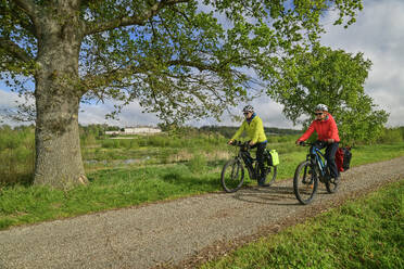 France, Centre-Val de Loire, Man and woman cycling along dirt road in Loire Valley - ANSF00687