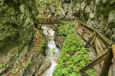 Österreich, Tirol, Wanderer stehen auf einer Brücke in der Wolfsklamm - ANSF00699