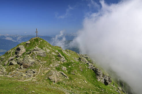 Österreich, Tirol, Gipfelkreuz auf dem Gilfertgipfel mit dicker Wolke im Vordergrund - ANSF00726