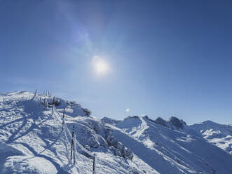 Österreich, Tirol, Axamer Lizum, Sonnenschein über schneebedecktem Hang in den Alpen - MMAF01502