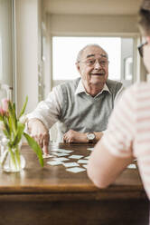Großvater und Enkel spielen zu Hause Karten - UUF30866
