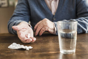 Senior man taking medicines at home - UUF30871