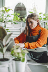 Botanikerin arbeitet am Laptop im Pflanzenladen - OLRF00037