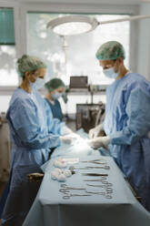 Surgical equipment arranged on table with animal surgeons in background at hospital - MASF41500