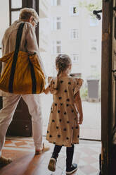 Senior woman with granddaughter leaving from building - MASF41522