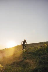 Woman exercising on hill against sky - MASF41575