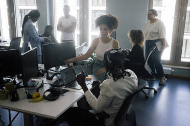 Multiracial male and female entrepreneurs working together at coworking office - MASF41716