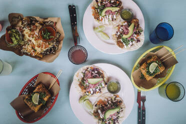 Directly above view of fresh street tacos with snacks and drinks arranged on table at restaurant - MASF41790