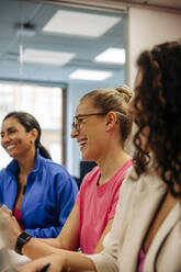 Happy female entrepreneur with colleagues during meeting at office - MASF41968