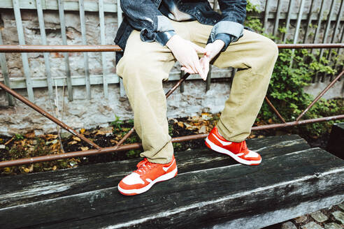 Low section of boy sitting on railing - MASF42125