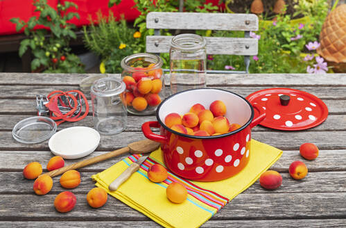 Zubereitung von Aprikosenkonfitüre auf einem Holztisch im Garten - GWF07978