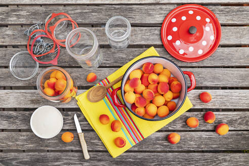 Preparation of apricot preserves on wooden garden table - GWF07979