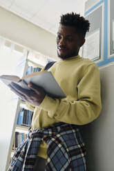 Ein Student liest ein Buch in der Bibliothek - DSHF01496