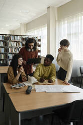 Eine Gruppe von Studenten diskutiert in der Bibliothek - DSHF01511