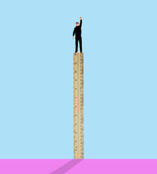 Man standing on ruler against colored background - GWAF00451