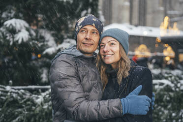 Lächelnder Mann und lächelnde Frau auf dem Weihnachtsmarkt - TILF00042