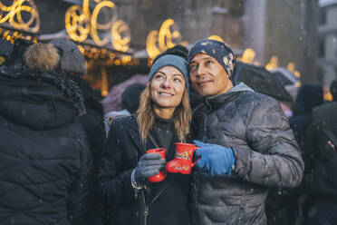 Smiling man and woman holding cups of punch drink - TILF00046