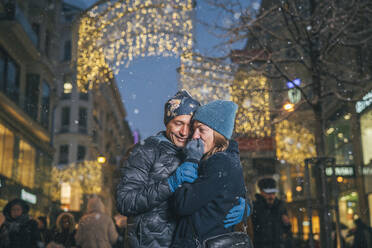 Happy couple embracing and having fun at Christmas market - TILF00065