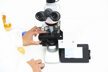 Scientist positioning sample into microscope at laboratory - PCLF00878