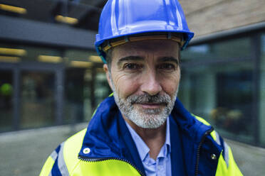 Smiling engineer wearing blue hardhat - JOSEF22455