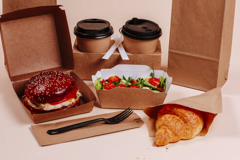 Fast foods with burger and coffee cups against beige background - MDOF01785