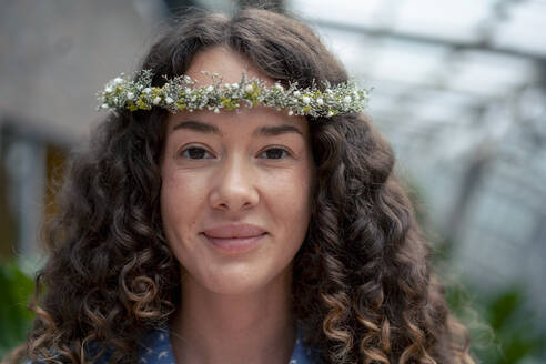 Smiling businesswoman with curly hair wearing tiara - JOSEF22690