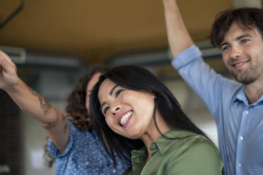 Cheerful colleagues dancing in lobby at office - JOSEF22717