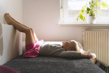 Glückliches Mädchen auf dem Bett liegend zu Hause - NDEF01522