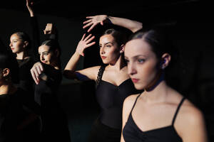 Flamenco dancers practicing together against black background - MRRF02732